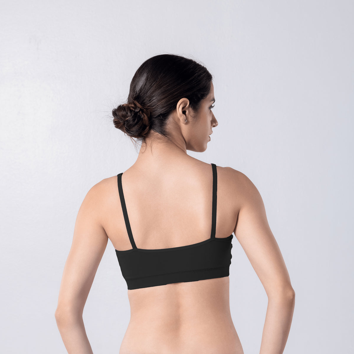 Feel Active Bra in Black, back view worn by model.